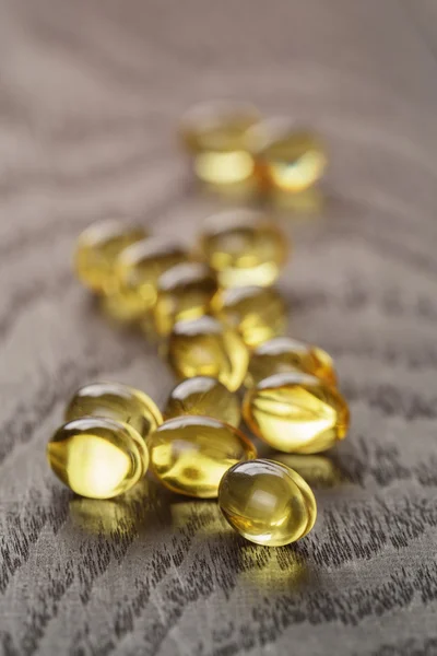 Fish oil capsules on wooden tabe