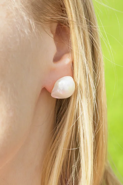 Woman's ear with a pearl earring