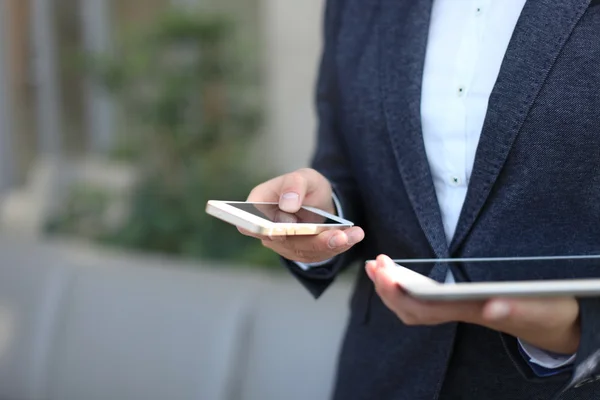 Young businesswoman working with modern devices, digital tablet computer and mobile phone