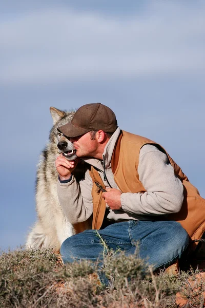 ARIZONA, USA - APRIL 16: Unidentified man - animal trainer sits with gray wolf on April 16, 2007 in Arizona, USA. The gray wolf is one of the world\'s best known and well researched animals.