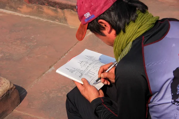 AGRA, INDIA - JANUARY 29: Unidentified man makes sketch of Itimad-ud-Daulah Tomb on January 29, 2011 in Agra, India. This Tomb is often regarded as a draft of the Taj Mahal