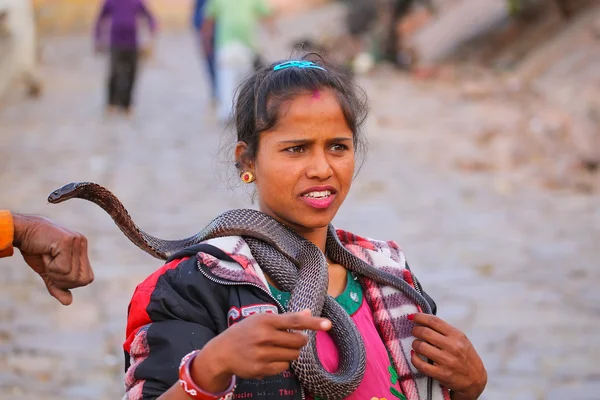 JAIPUR, INDIA - NOVEMBER 14: Unidentified woman stands with a cobra in the street on November 14, 2014 in Jaipur, India. Jaipur is the capital and largest city of the Indian state of Rajasthan.