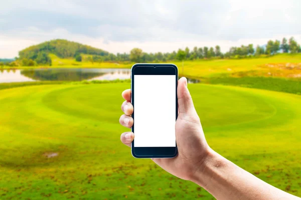 Hand using smartphone mobile in the vertical position, background blur of golf.