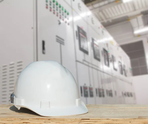 The engineering and a helmet for safety stands against electrical switches - switch electrical panel industry.