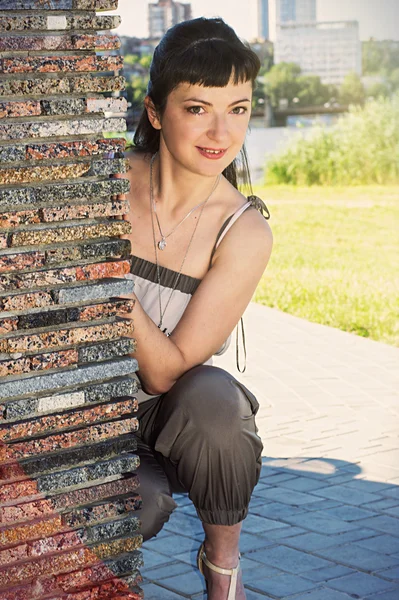 Beautiful girl looks out from behind the wall corrugated