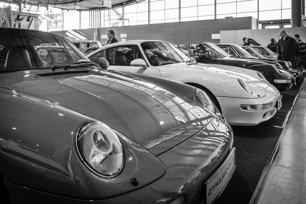 Various models of Porsche sports cars stand in a row.