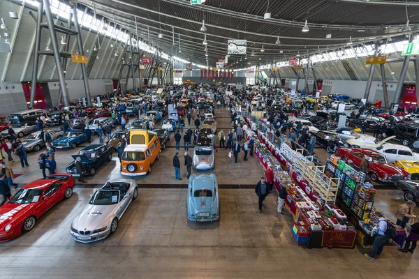 Different cars and bikes in the exhibition hall.