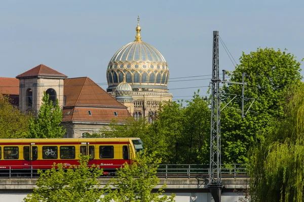 Urban rail S-Bahn (foreground) on the background of the dome Neue Synagoge (New Synagogue).