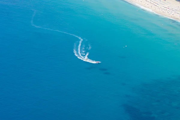 ALANYA, TURKEY - JULY 09, 2015: Mediterranean Sea. Traditional entertainment resort of Alanya. Water sports, riding on a motorboat along the coast. View from the bird\'s-eye view.