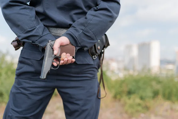 Detail of a police officer holding gun.