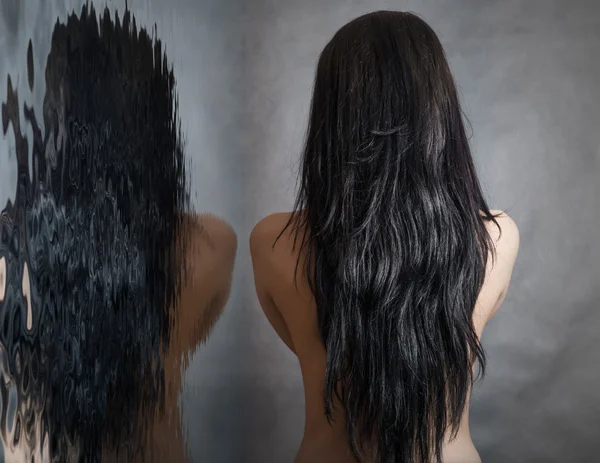 Woman with beautiful black hair on dark