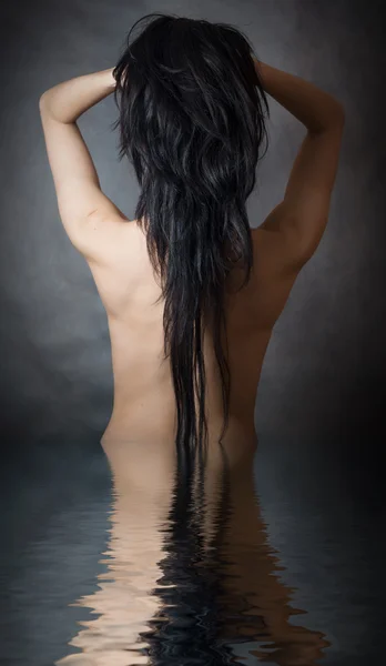 Woman with beautiful black hair on dark