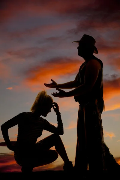 Silhouette of blonde woman crouch hand on head cowboy