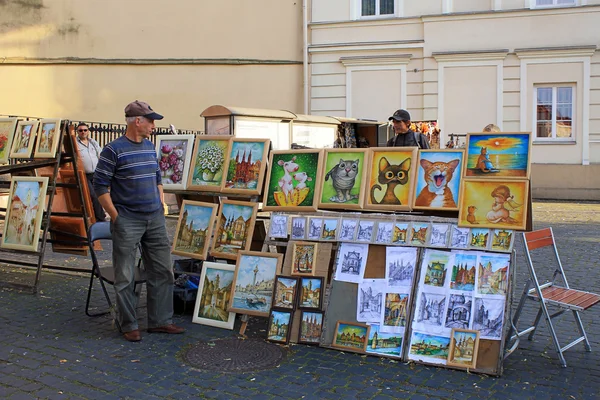Street artists sell paintings to the tourists on the street mark