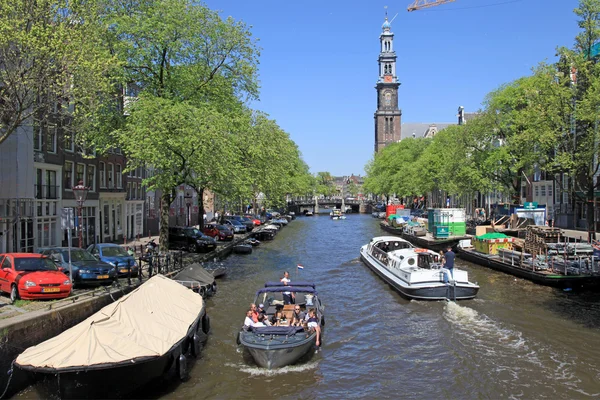 People enjoy a boat ride in the canals of Amsterdam.