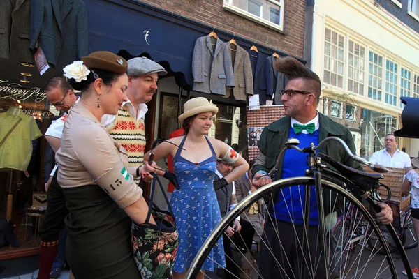 Unidentified people in vintage style clothes with their bicycles