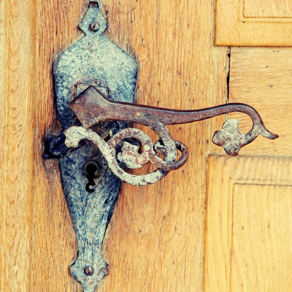 Old rusty iron handle in medieval door