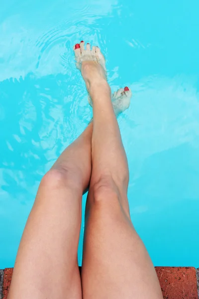 Female legs relaxing in pool
