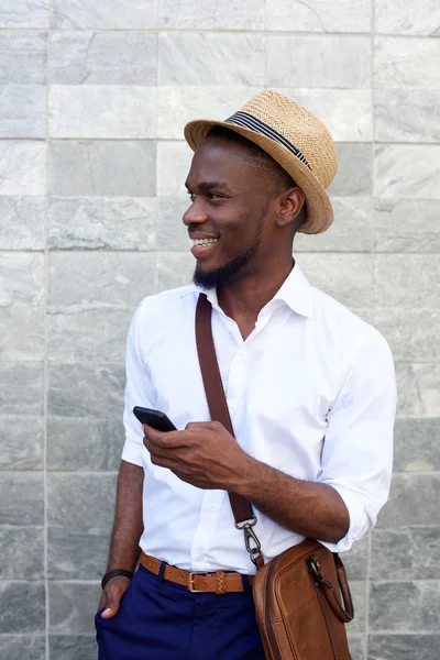 Young african man smiling with mobile phone