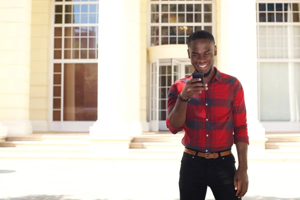 Young african man looking at mobile phone