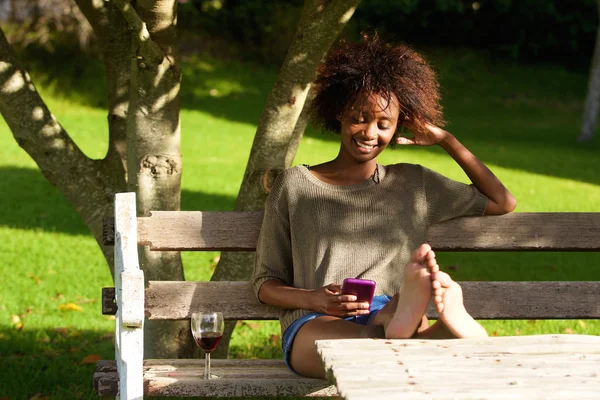 Smiling black woman sitting in park