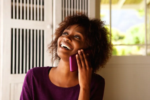 Young black woman smiling with cell phone