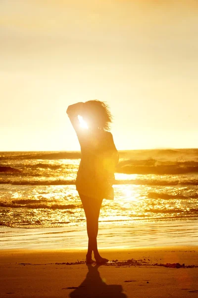 Silhouette of fashion model walking on beach