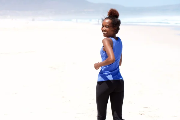 Smiling young african woman jogging