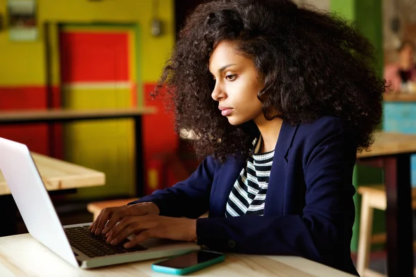 African woman using laptop at coffee shop