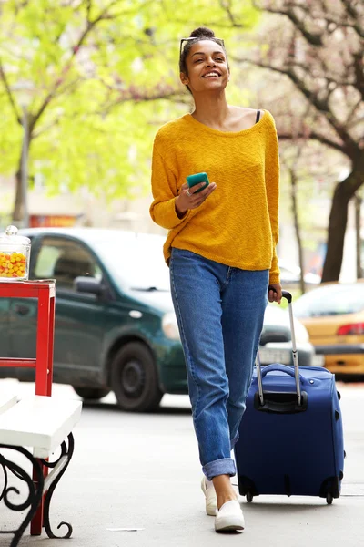 Attractive woman with suitcase and mobile phone
