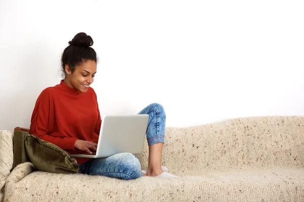 Attractive woman sitting on couch with laptop