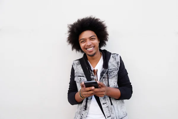 Laughing man standing with cell phone