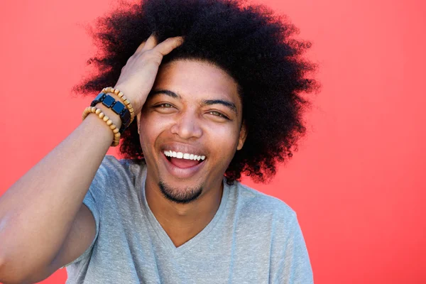 Laughing young man with hand in afro hair