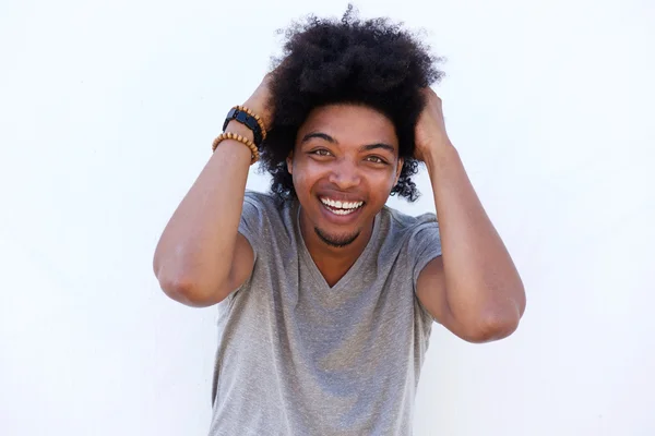 Young man laughing with hand in hair