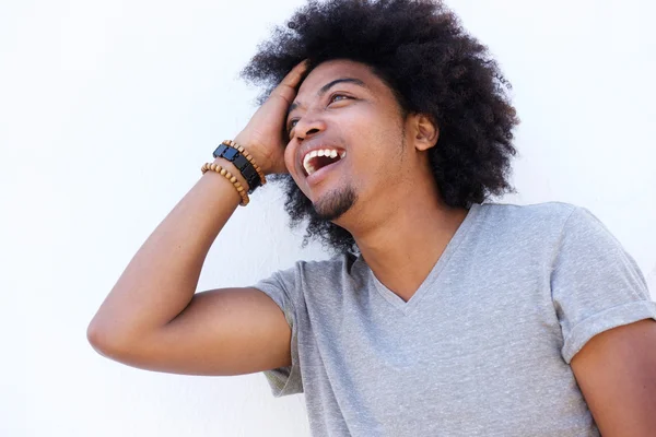 Laughing man standing with hand in hair