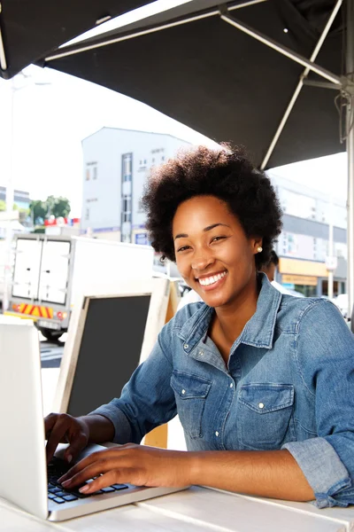 Smiling african lady working on computer