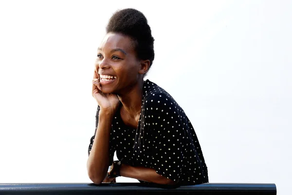 Smiling young african lady leaning on railing