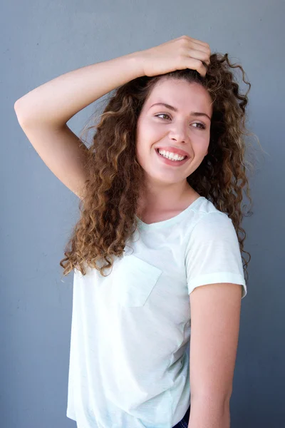 Smiling girl standing with hand in hair