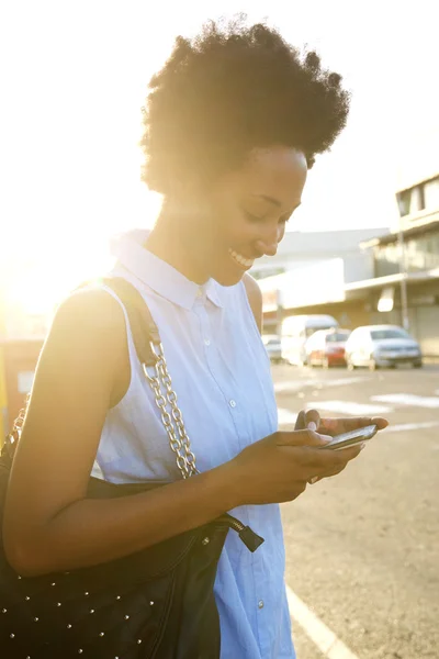 Happy african woman using mobile phone