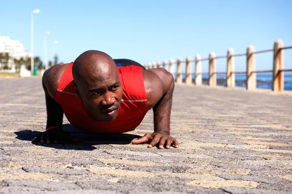 Muscular young man doing push up exercise