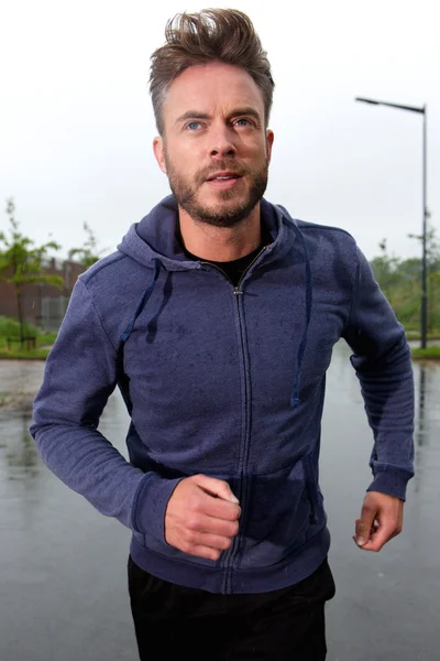 Carefree middle aged runner in rain