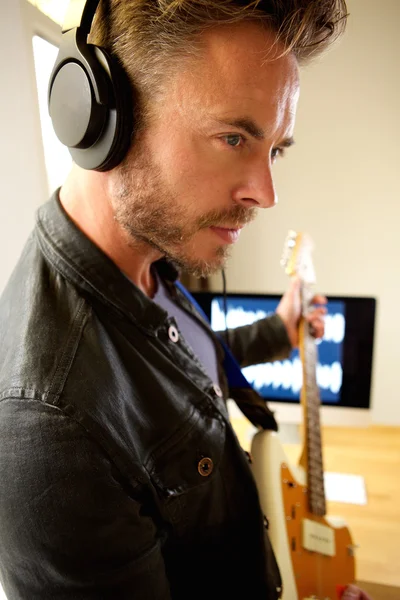 Musician with headphones and electric guitar