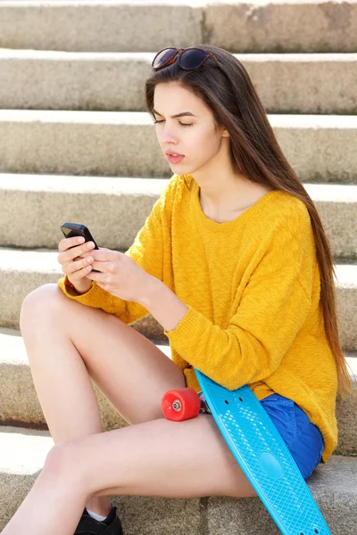 Woman sitting on steps with smart phone
