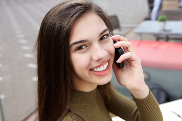 Smiling young woman on phone call outside