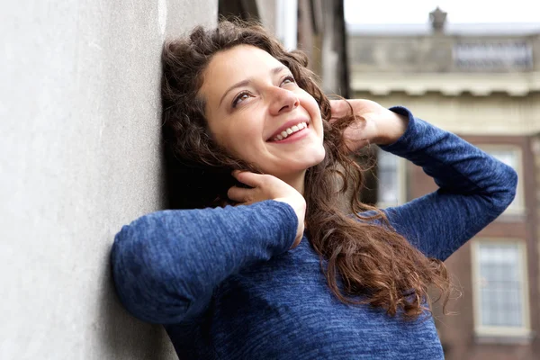 Woman leaning to a wall outdoors