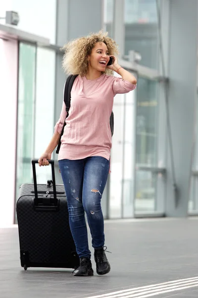Smiling female traveler with suitcase