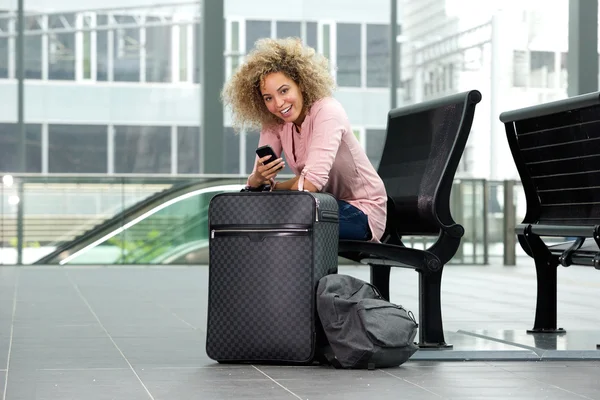 Female traveler sitting with suitcase