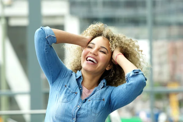 Woman laughing with hands in hair
