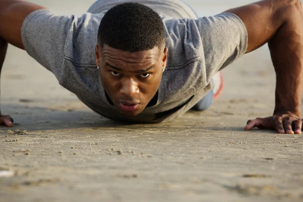 Young man doing push ups outdoors