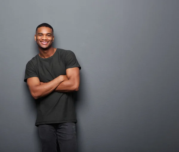 Happy young man standing with arms crossed